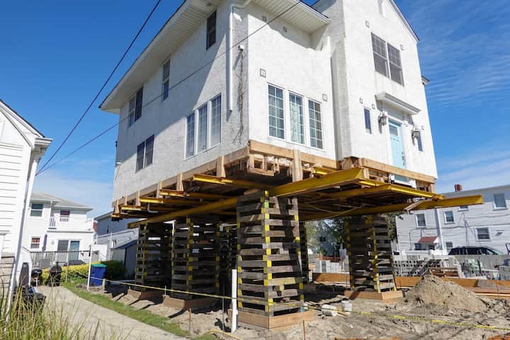 A team of professionals using specialized equipment to raise a house in Glen Allen, preparing it for elevation and renovation